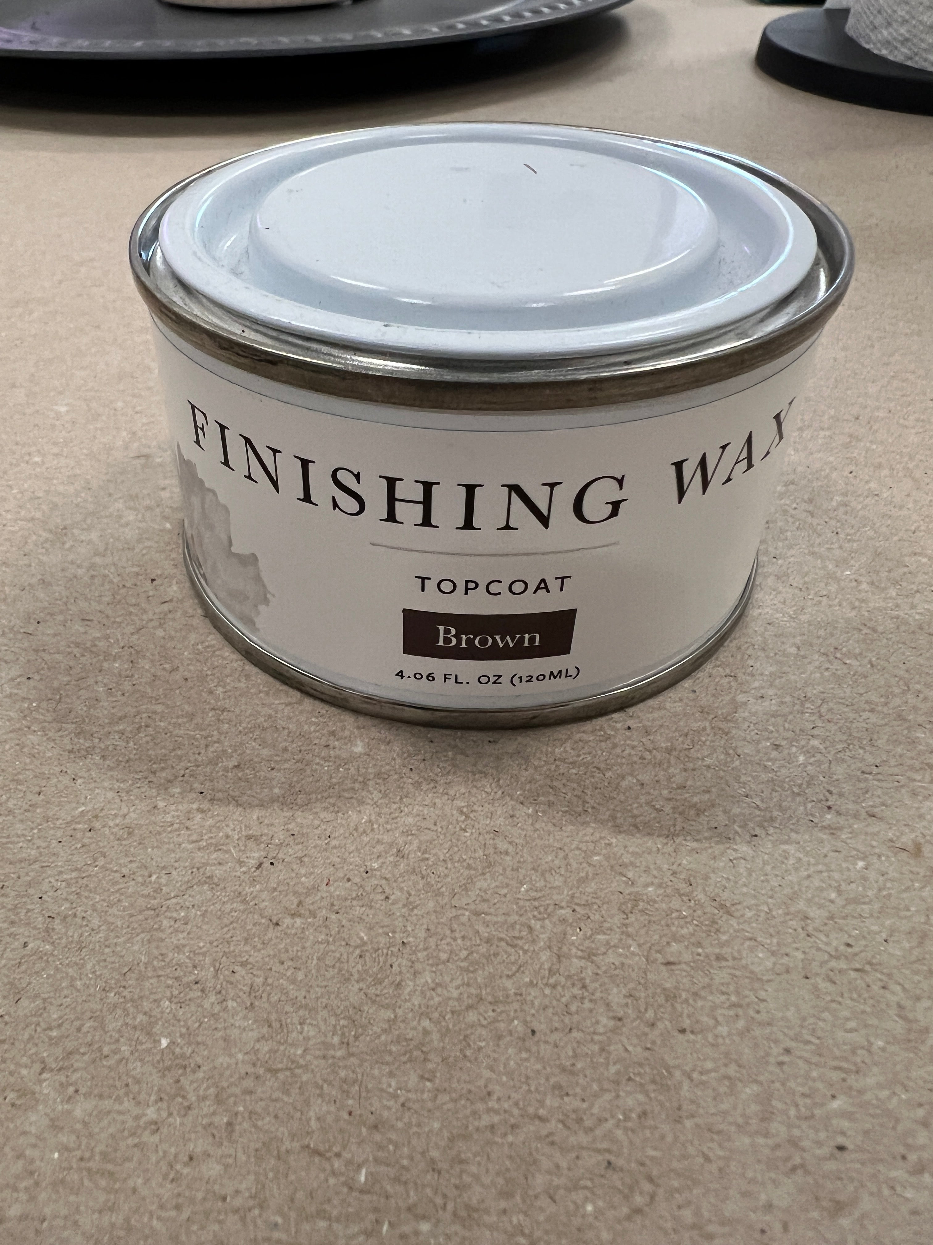 Can of Finishing Wax Topcoat on a textured surface