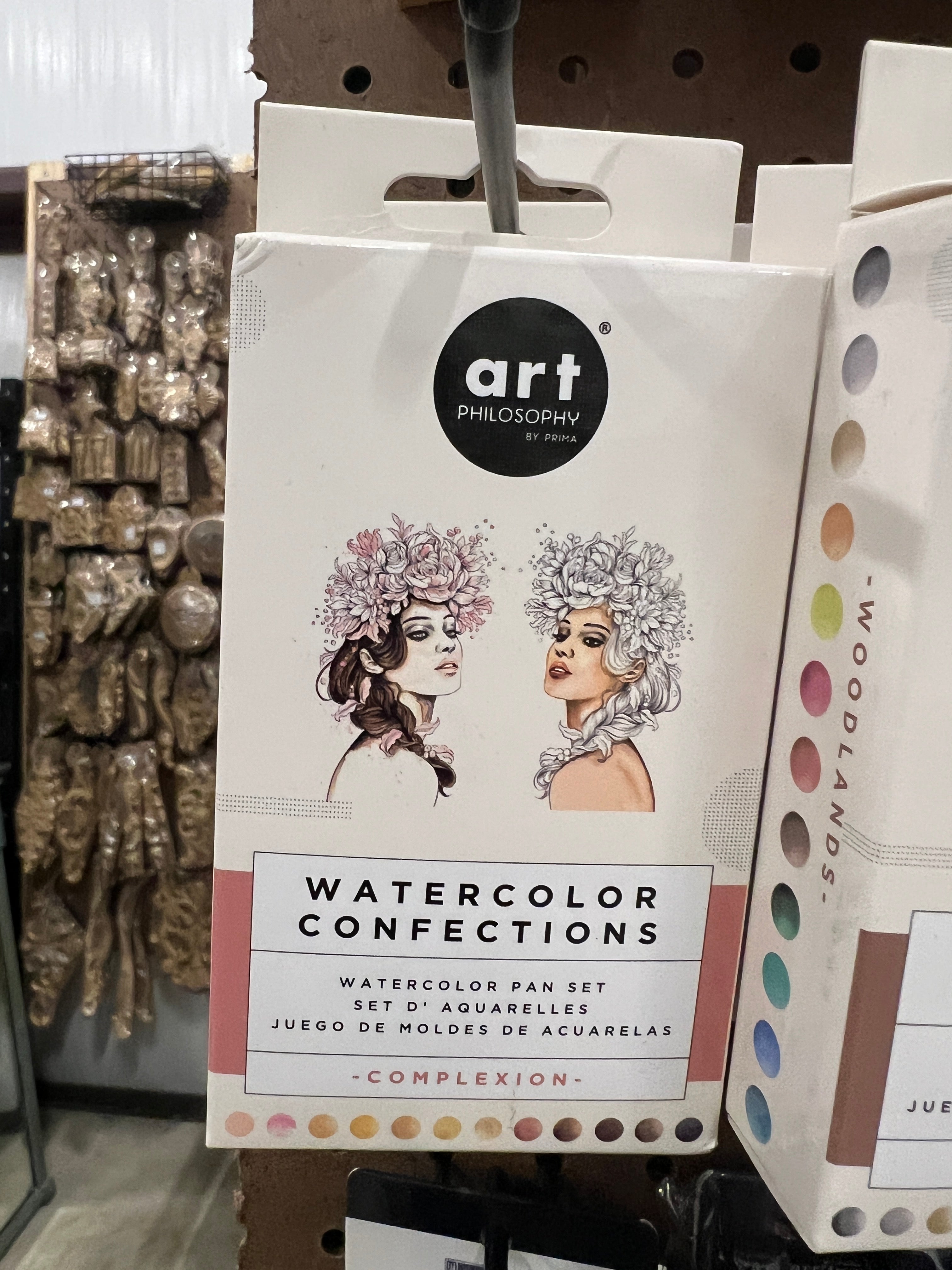 Watercolor paint set packaging with branding and product details on a shelf.