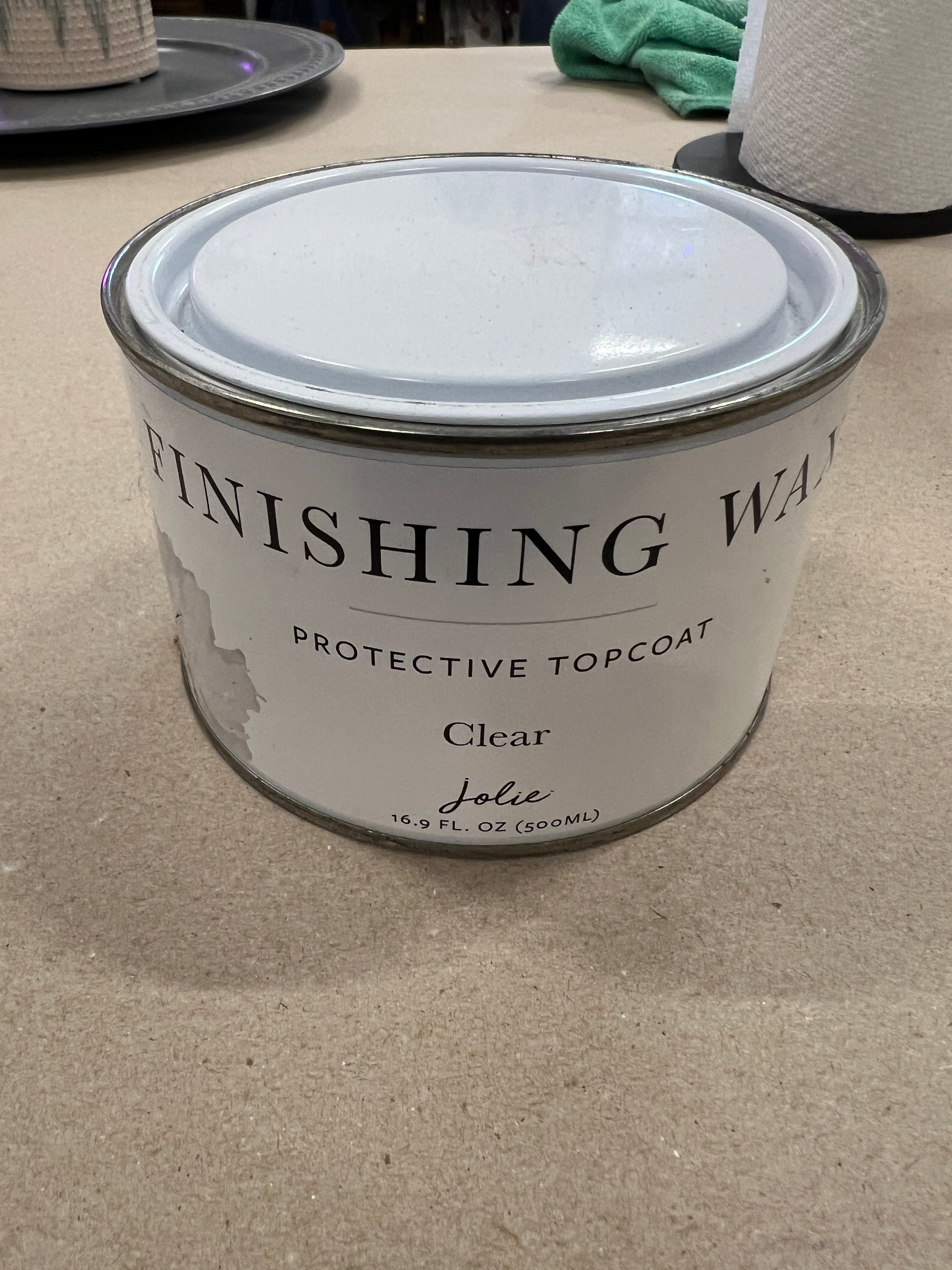 Can of Finishing Wax on a concrete surface with tools in the background
