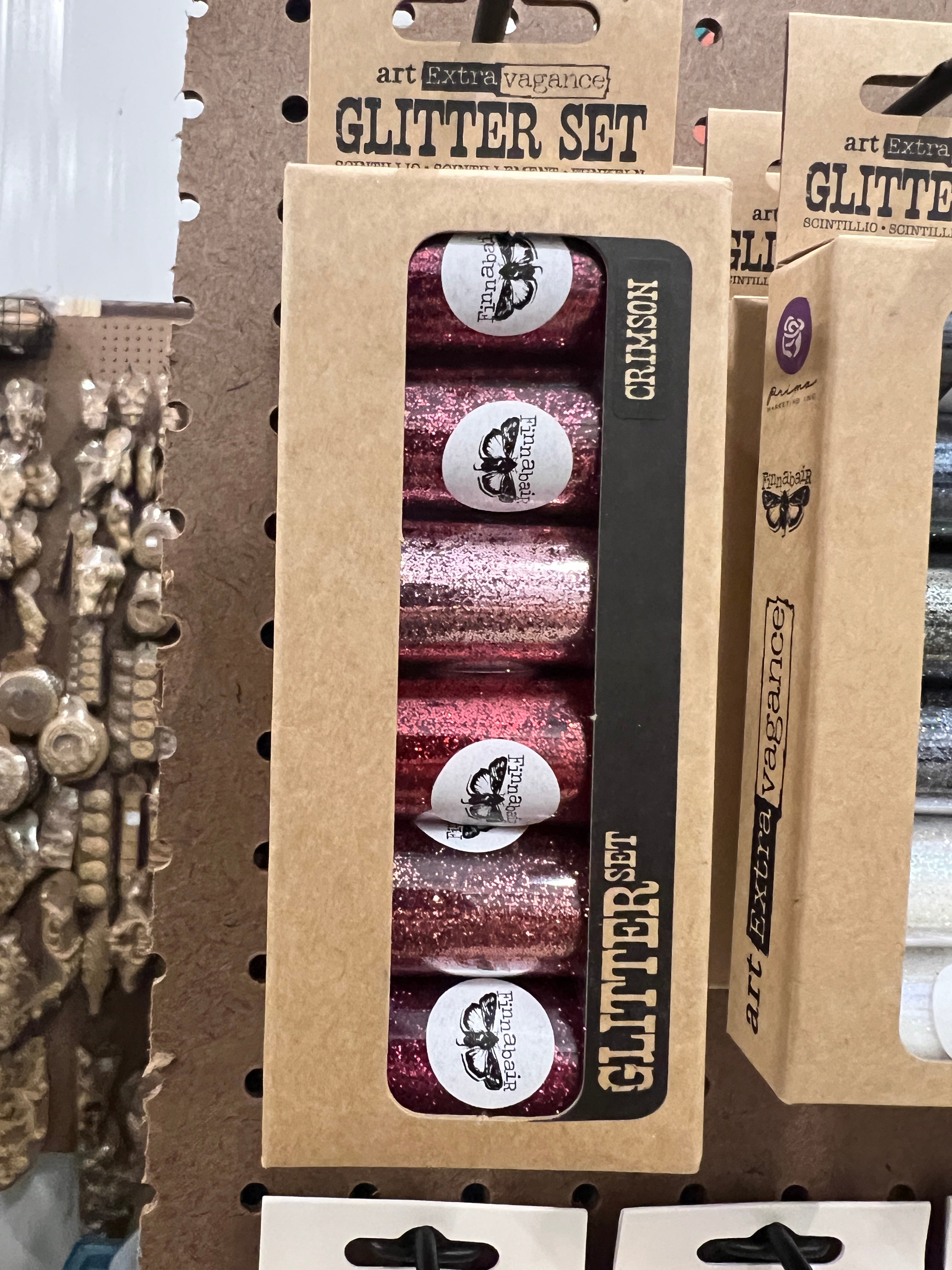 Set of glittery nail polish bottles in a cardboard holder with visible branding.