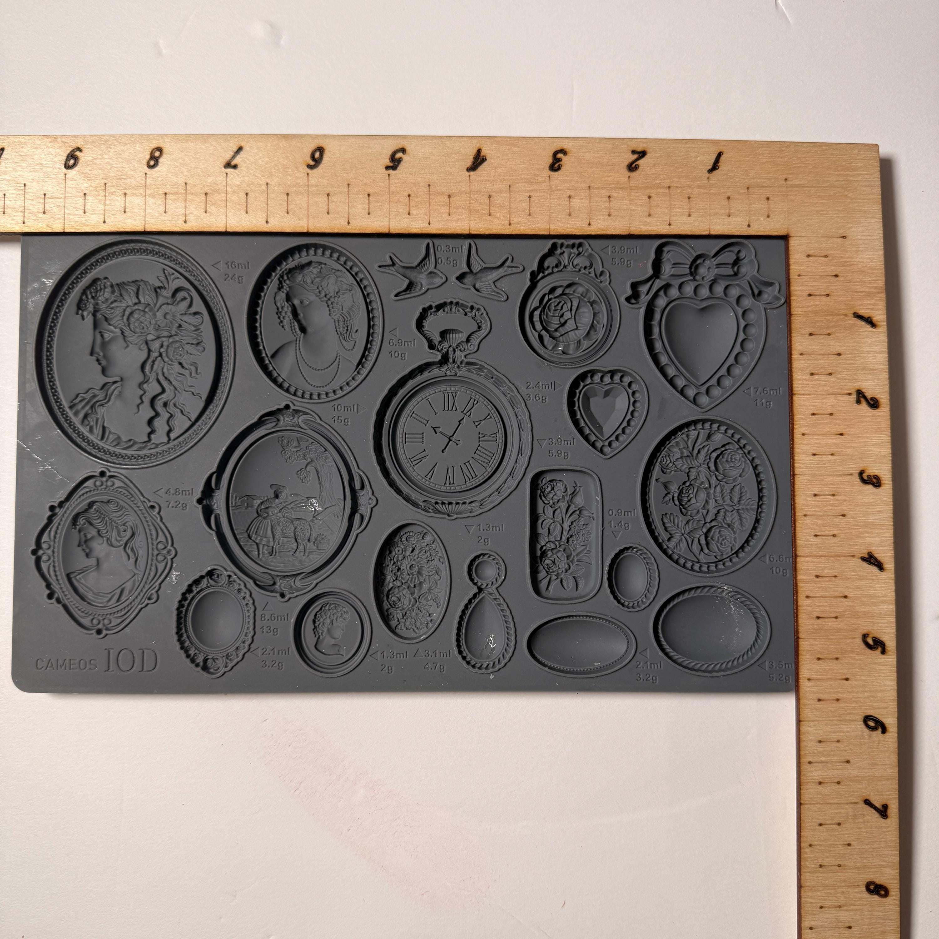 Decorative mold with various shapes on a wooden ruler for scale