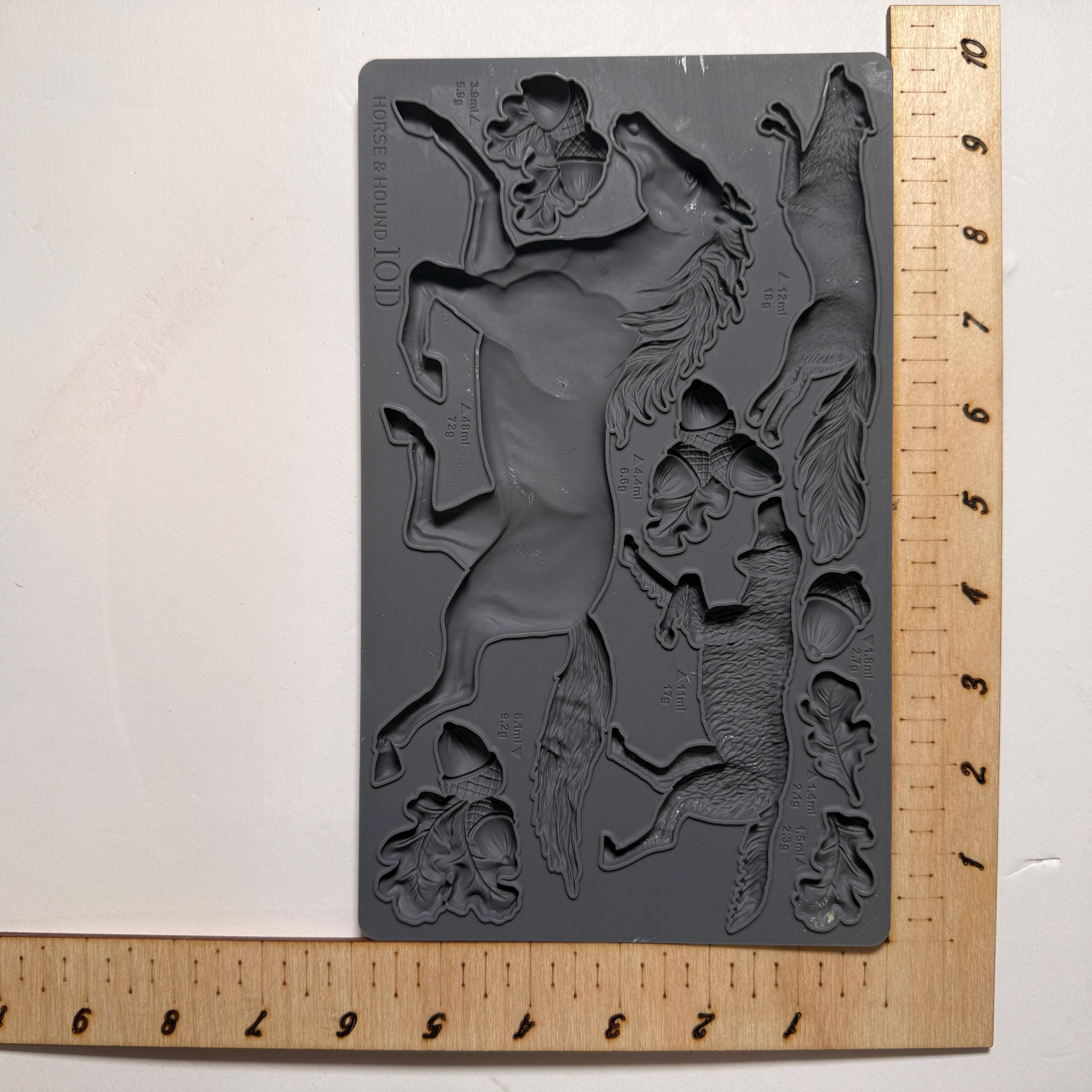 Silicone mold with horse design next to a ruler on a white background