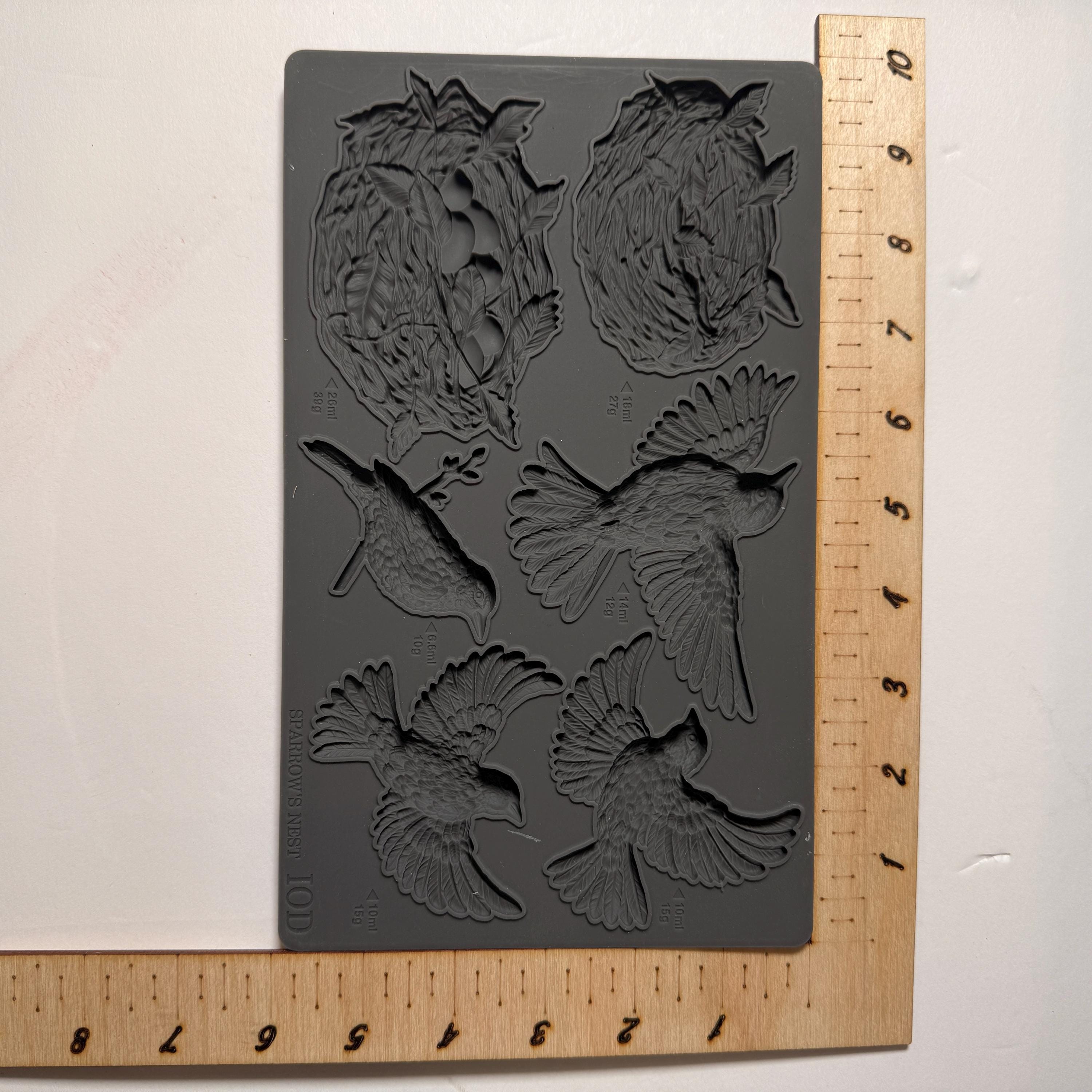 Silicone mold with bird shapes on a gray background with a ruler for scale.