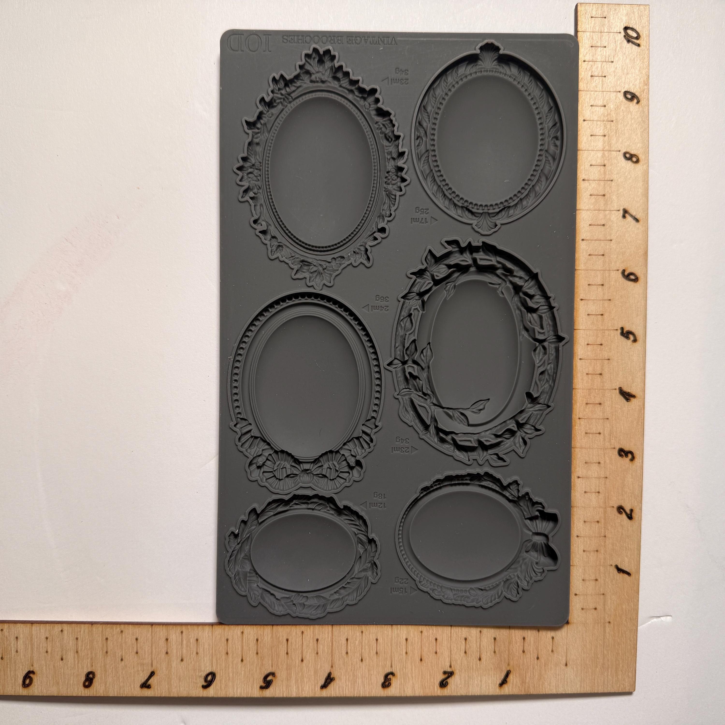 Silicone mold with decorative frames on a wooden ruler for size reference