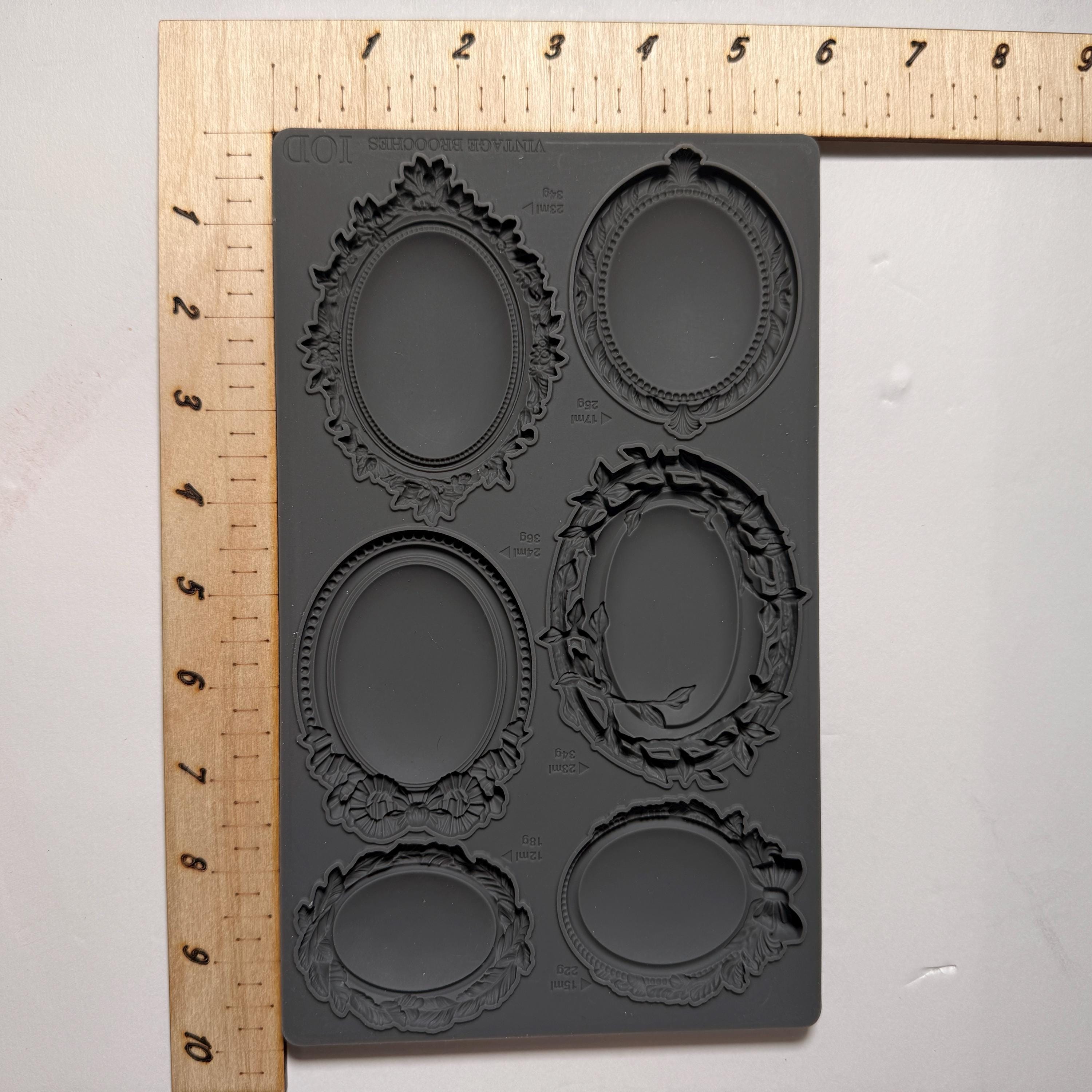 Silicone mold with decorative shapes on a white background with a ruler for scale.