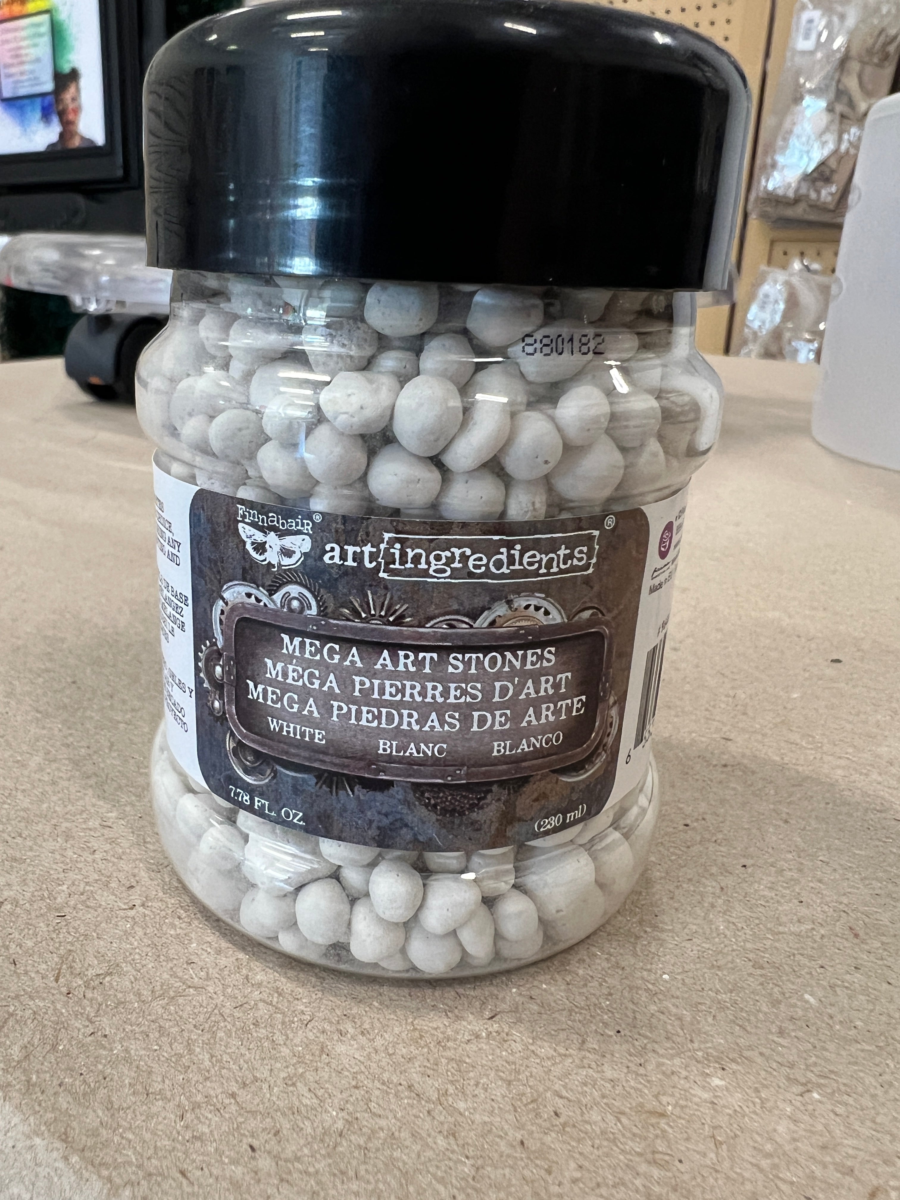 Jar of artiflengedentis Megart Stones on a beige surface